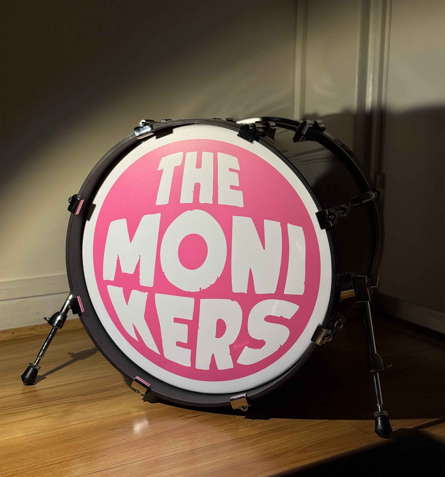 Drum with 'The Monikers' logo on a wooden floor